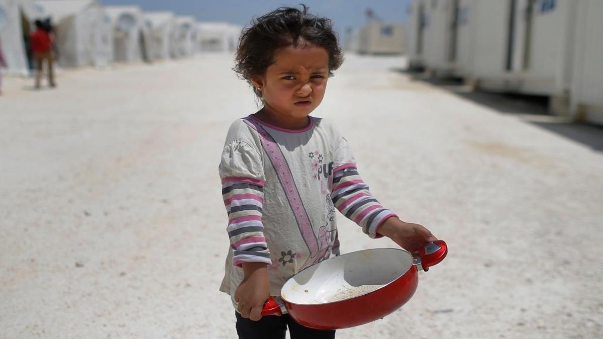 In this June 19, 2015 file photo, a Syrian refugee child walks at a refugee camp in Suruc, on the Turkey-Syria border. Some 28 million children around the globe have been driven from their homes by violent conflict, with nearly as many abandoning their homes in search of a better life, according to a UNICEF report released Tuesday, Sept. 6, 2016. The report found that while children make up about a third of the world's population as of 2015, they accounted for nearly half of all refugees, with the number of child refugees having doubled in the last decade.