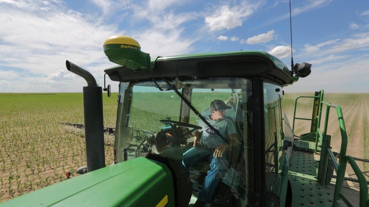 Braden Scott drives a crop sprayer over an irrigated cornfield near Ulysses, Kan., on June 9, 2015. Farmers in Kansas and other rural states would see a 36 percent cut to crop insurance under President Donald Trump’s budget proposal.