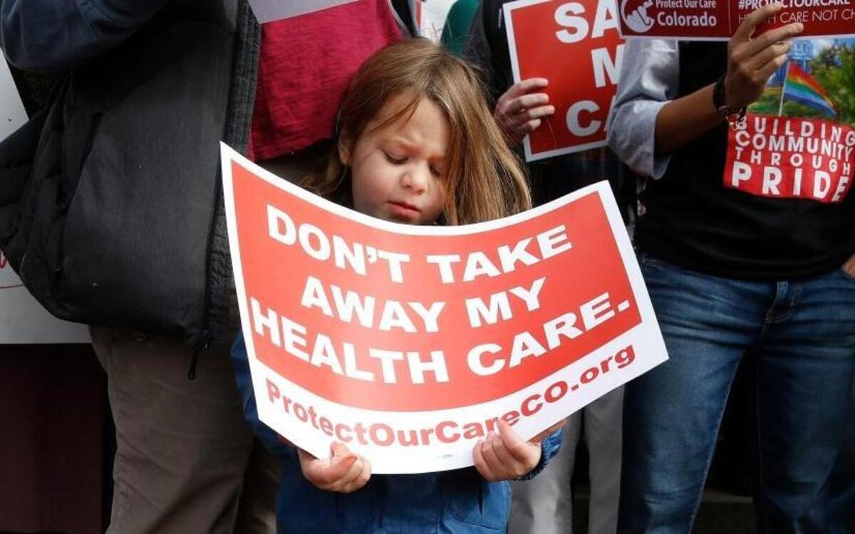A young girl holds a sign alongside supporters of the Affordable Care Act at a January rally on the state Capitol steps in Denver. Women’s health advocates say Republican proposals to replace Obamacare will disproportionately hurt women and their families.