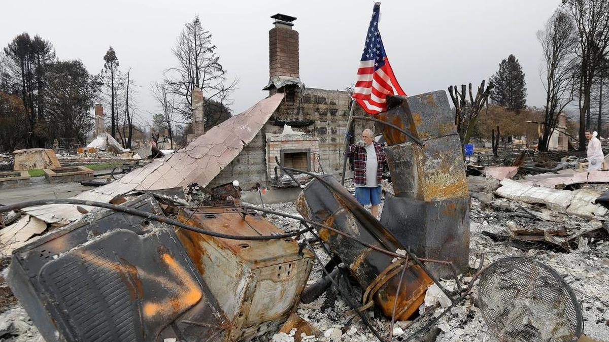 Larry Keyser looks around as he and volunteers from Samaritan's Purse disaster relief sift through remains of his family's home destroyed by fires in the Coffey Park area of Santa Rosa, Calif., Wednesday, Nov. 8, 2017. Rumbling front loaders began scraping up the ash and rubble of nearly 9,000 destroyed homes and other structures in Northern California this week as the U.S. Army Corps of Engineers launched a new phase of the largest wildfire clean-up in the state's history.