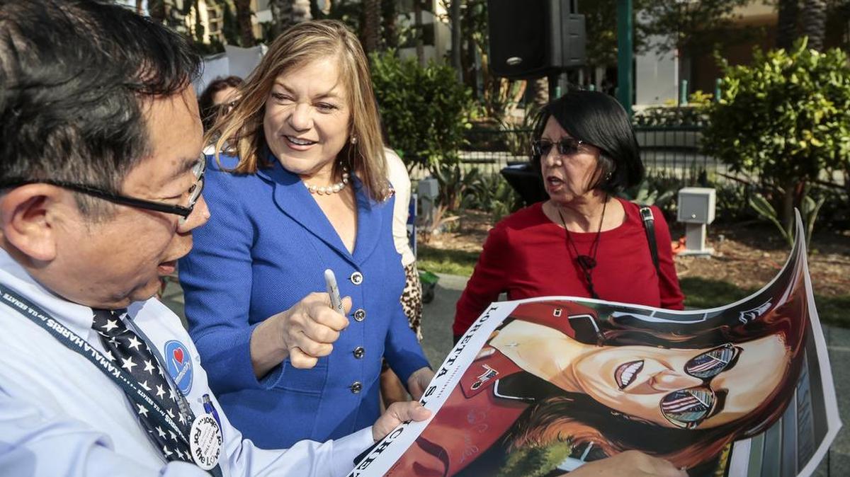 Rep. Loretta Sanchez, second from left, autographs a California Senate race campaign poster for an unidentified supporter at the California Democratic Party state convention in Anaheim in May.