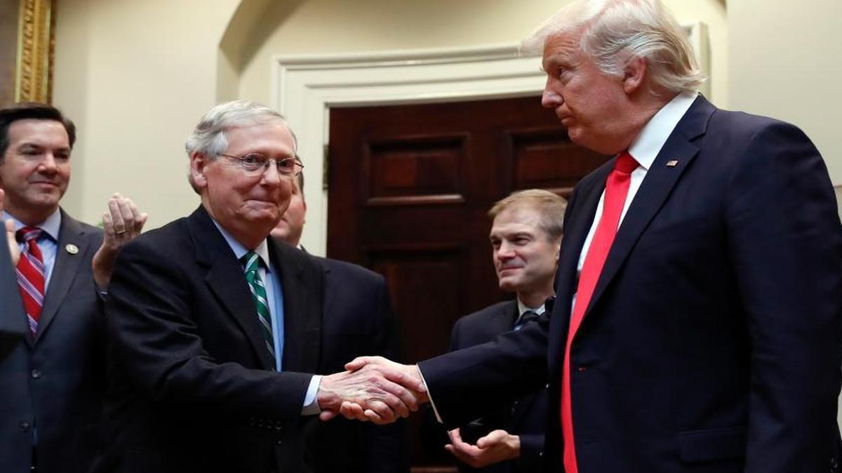 President Donald Trump shakes hands with Senate Majority Leader Mitch McConnell, R-Ky., during a ceremony where he was to sign H.J. Res. 38 in the Roosevelt Room of the White House in Washington, Feb. 16, 2017. Behind from left are Reps. Evan Jenkins, R-W.Va., and Jim Jordan, R-Ohio.