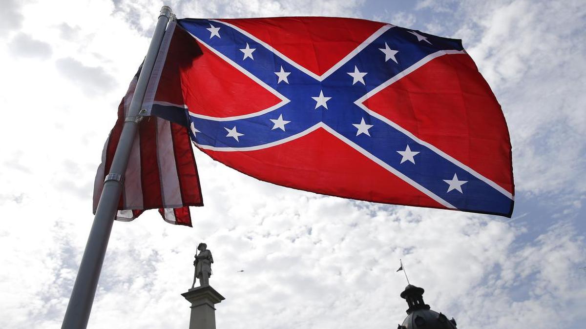 
A protester waves a Confederate battle flag in front of the South Carolina statehouse. More than 50 years after the state raised the flag at its statehouse to protest the civil rights movement, the rebel banner is scheduled to be removed Friday morning during a ceremony.

