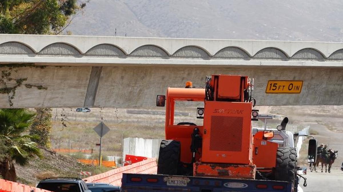 Heavy construction equipment is trailered in at the entrance that leads to where the prototype border walls will be constructed along the U.S.-Mexico border, on the corner of Enrico Fermi Drive and Via De La Amistad.
