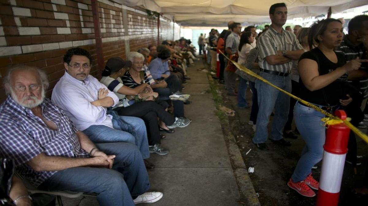 People line up outside a school set up as a validation center to certify the authenticity of their signatures in Caracas, Venezuela, Monday, June 20, 2016. Venezuela starts a crucial stage in the possible recall referendum against President Nicolas Maduro with the validation of 1.3 million signatures supporting the referendum. The U.S. House Foreign Affairs Committee held a hearing on Venezuela’s future on Wednesday, June 22, 2016.
