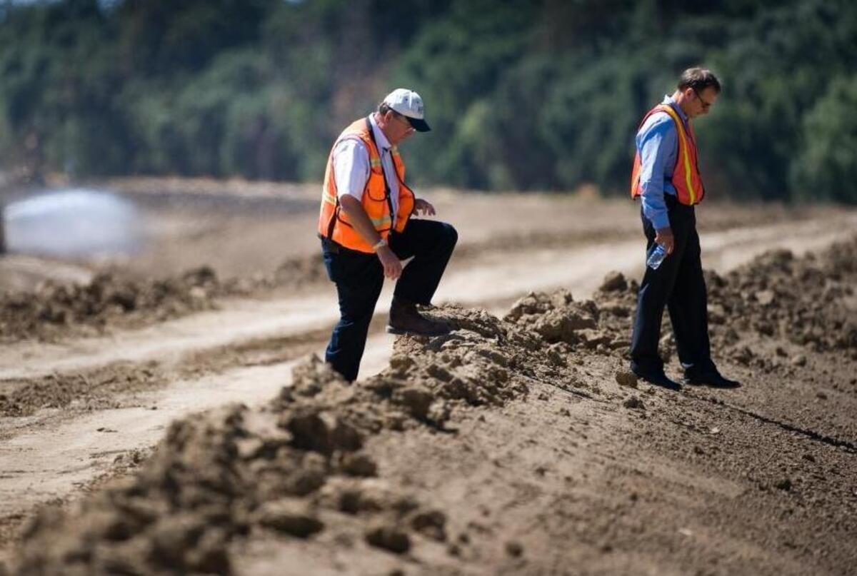 John Bassett, Director of Engineering (left) and Peter Buck, Natural Resources Supervisor for the Sacramento Area Flood Control Agency, make their way over a levee under construction in September 2010.