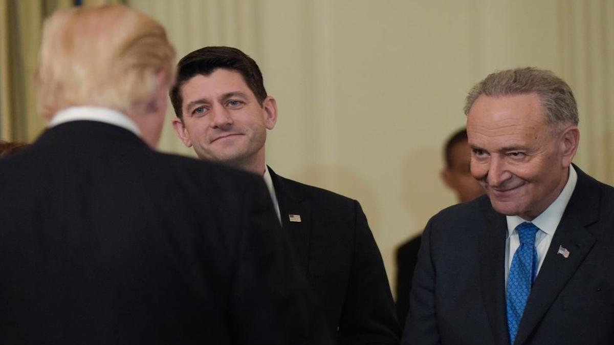 President Donald Trump talks with House Speaker Paul Ryan, R-Wis., center, and Senate Minority Leader Chuck Schumer, D-N.Y., during a reception for House and Senate leaders in the the State Dining Room of the White House on Monday, Jan. 23, 2017.