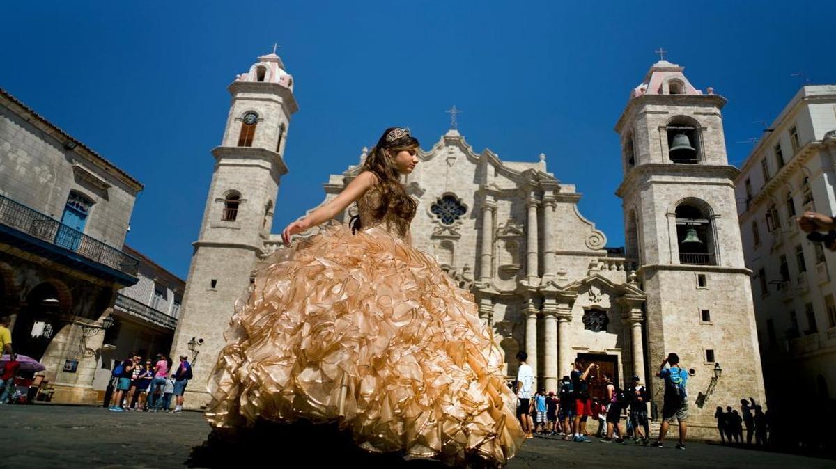 A "quinceanera" poses during her photo session in front of the cathedral as tourists line up to enter the building in Havana on March 14, 2016. Lawmakers want to block scheduled commercial airline service to Cuba until the TSA certifies that Cuban airports meet American security standards.
