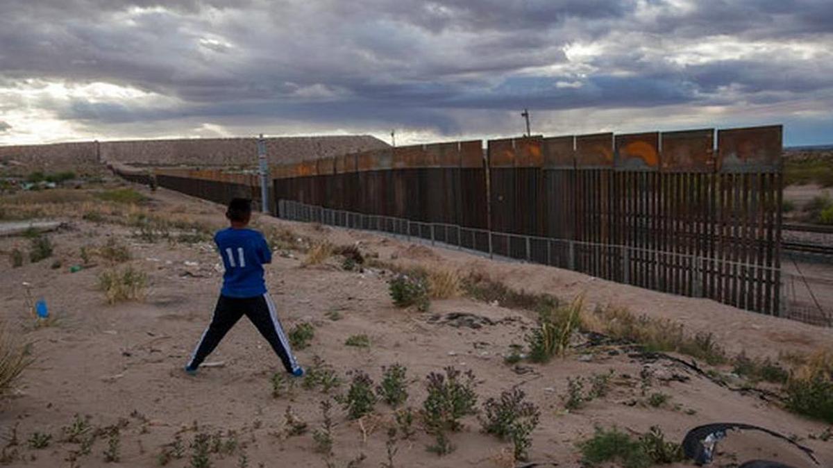 In this March 29, 2017, file photo, a youth looks at a new, taller fence being built along U.S.-Mexico border, replacing the shorter, gray metal fence in front of it, in the Anapra neighborhood of Ciudad Juarez, Mexico, across the border from Sunland Park, New Mexico.