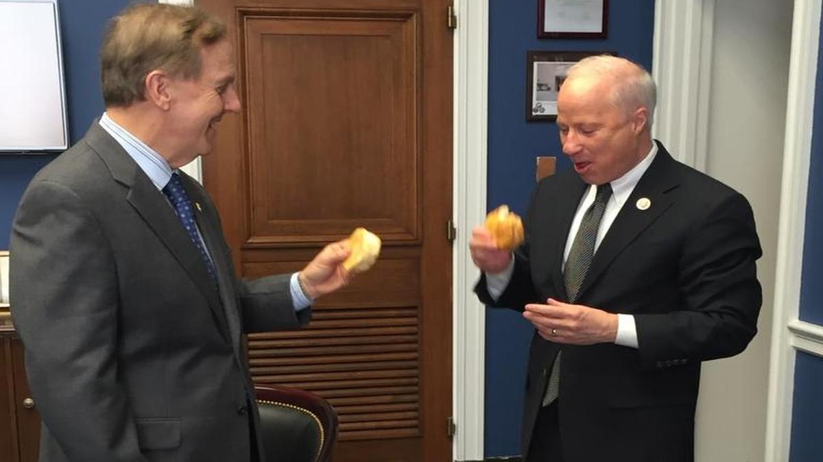 North Carolina Rep. Robert Pittenger, left, pays off a Super Bowl bet to Colorado Rep. Mike Coffman.