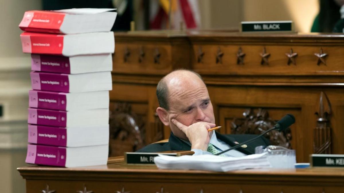 Rep. Tom Reed, R-N.Y., listens as he sits next to a stack of IRS Code volumes as the House Ways and Means Committee begins writing the GOP's far-reaching tax overhaul.