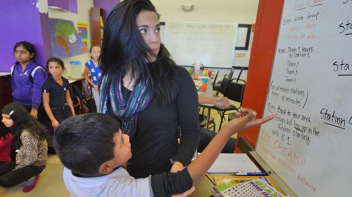 OurBRIDGE Executive Director Sil Ganzo listens to student Juan Carlos Diaz Lorenzo, age 7, in Charlotte, N.C., on Oct. 17, 2014. OurBRIDGE works with refugee and immigrant students. The students come to Charlotte from 22 countries. The program helps them with homework, provides English-language tutoring and creates an environment where they can learn from others going through the same experience.