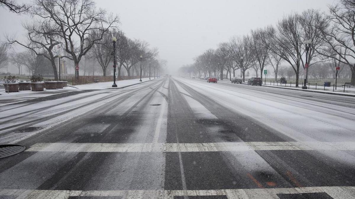 Constitution Avenue is seen almost empty of cars as snow begins to blanket Washington, Friday, Jan. 22, 2016. A blizzard menacing the Eastern United States started dumping snow in Washington, Virginia, Tennessee and other parts of the South on Friday as millions of people in the storm’s path prepared for icy roads, possible power outages and other treacherous conditions.