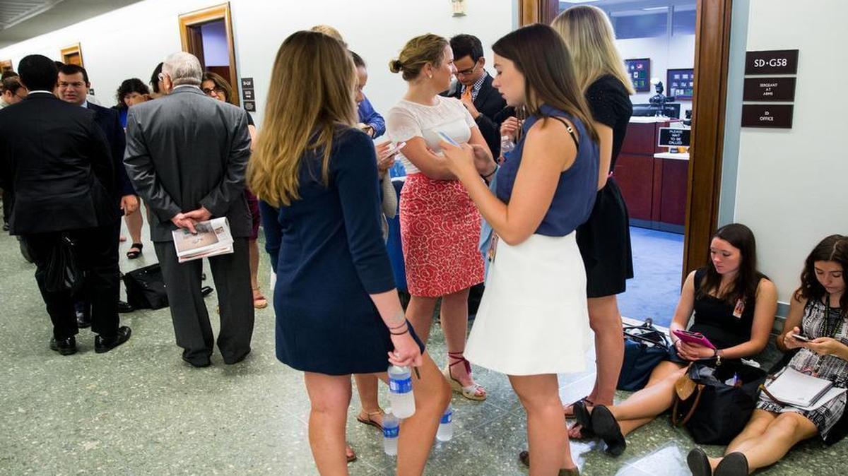 
Spectators wait outside the hearing room as the Senate Foreign Relations Committee begins consideration of the Iran nuclear agreement.
