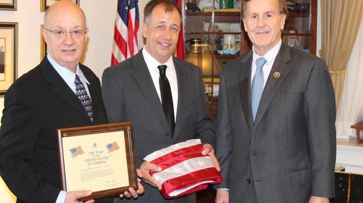 In honor of their father, Garland Denny, James and Chuck Denny, left and center, accept the U.S. flag from U.S. Rep. Robert Pittenger in Washington, D.C., on Oct. 21, 2015.