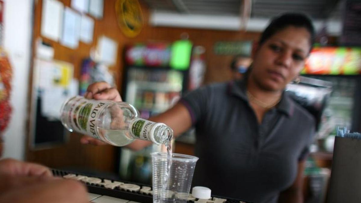 In this Friday, Sept. 7, 2012, file photo, a bartender fills a glass with rum at a bar in San Juan, Puerto Rico Small producers in countries such as Antigua, Guyana and Jamaica complain they are being punched by unfair trade and marketing advantages for global beverage corporations operating in U.S. territories, and say U.S. rum subsidies threaten to drive some beloved top-shelf Caribbean labels out of business, or force them to sell out.