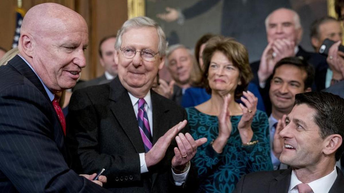 Speaker of the House Paul Ryan, R-Wis., right, shakes hands after presenting a pen to House Ways and Means Committee Chairman Kevin Brady, R-Texas, left, as Senate Majority Leader Mitch McConnell, R-Ky., second from left, watches after signing the final version of the GOP tax bill during an enrollment ceremony at the Capitol in Washington, Thursday, Dec. 21, 2017.