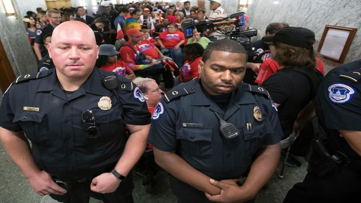 U.S. Capitol Police maintain order as hundreds of people, many with disabilities, arrive for a Senate Finance Committee hearing on the last-ditch GOP push to overhaul the nation's health care system, on Capitol Hill in Washington Monday.
