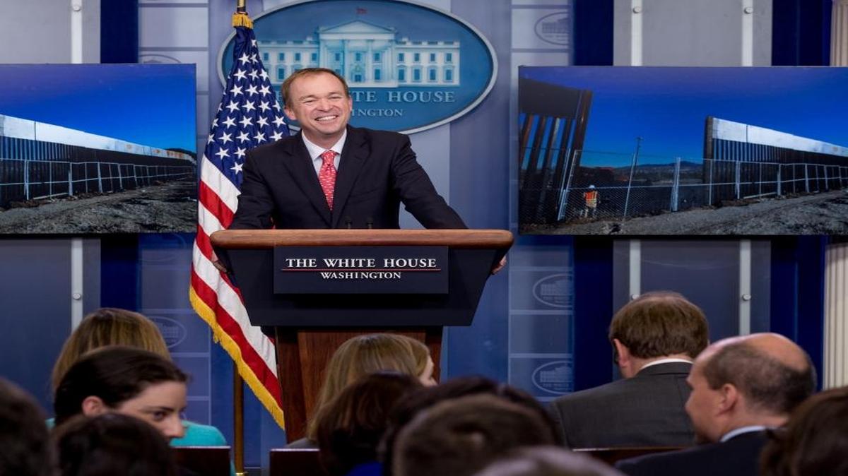 An image depicting different border walls is displayed behind Budget Director Mick Mulvaney as he speaks to the media during the daily press briefing at the White House, Tuesday, May 2, 2017, in Washington.
