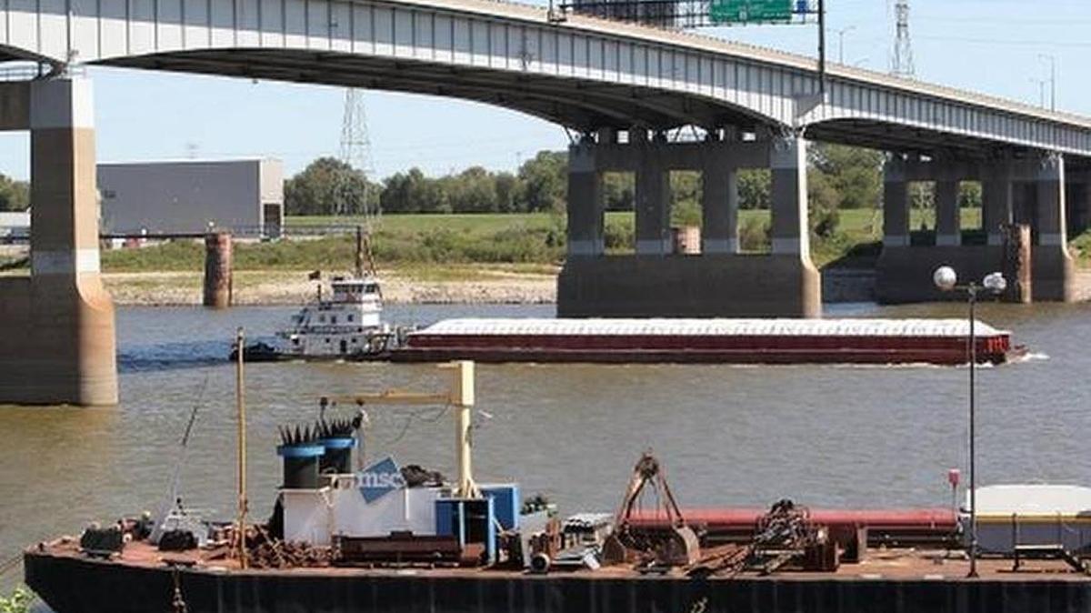 Mississippi River barges pass under the Poplar Street bridge in St. Louis.