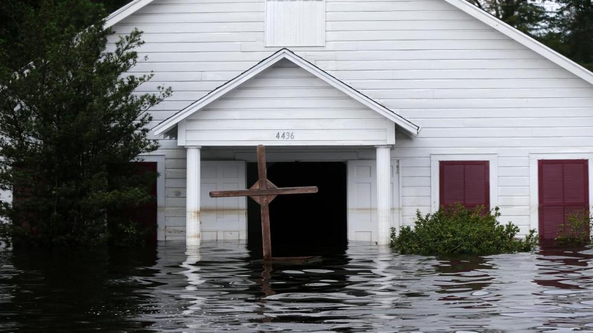 A crucifix stands in front of a flooded church in the aftermath of Tropical Storm Harvey in Vidor, Texas.