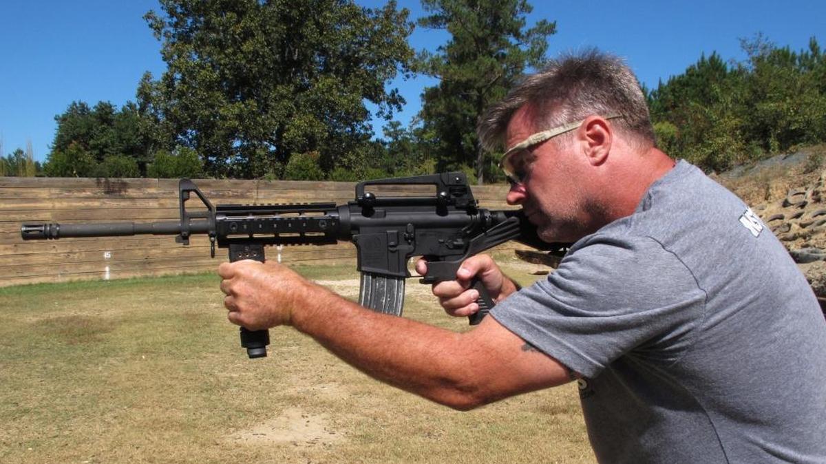 Shooting instructor Frankie McRae aims an AR-15 rifle fitted with a "bump stock" at his 37 PSR Gun Club in Bunnlevel, N.C., on Wednesday, Oct. 4, 2017. The stock uses the recoil of the semiautomatic rifle to let the finger "bump" the trigger, making it different from a fully automatic machine gun, which are illegal for most civilians to own.