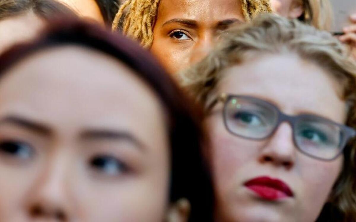 Participants listen to a speaker at the International Women's Day rally in the shadow of New York's Trump Tower, on March 8, 2017, in New York. The protest was part of a nationwide event called A Day Without a Woman. Many of the participants had taken a day off from work to show the impact women have on the American economy.
