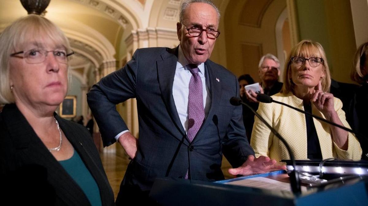 Senate Minority Leader Sen. Chuck Schumer of N.Y., accompanied by Sen. Patty Murray, D-Wash., left, and Sen. Maggie Hassan, D-N.H., right, speaks to reporters.