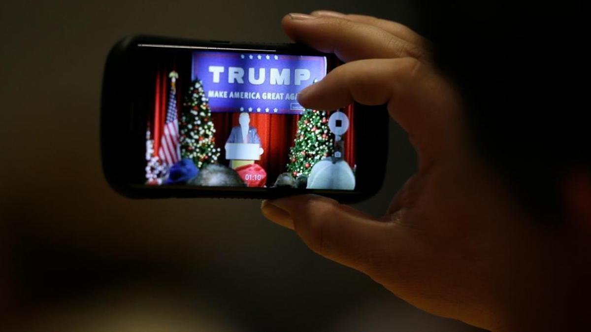 An audience member snaps a cell phone photo as Republican presidential candidate Donald Trump speaks during a campaign rally at the Veterans Memorial Building, Saturday, Dec. 19, 2015, in Cedar Rapids, Iowa.