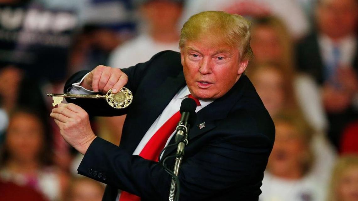 Republican presidential candidate Donald Trump holds up a key to the city he brought onto the stage with him as he speaks at a campaign rally Monday, March 7, 2016, in Madison, Miss.