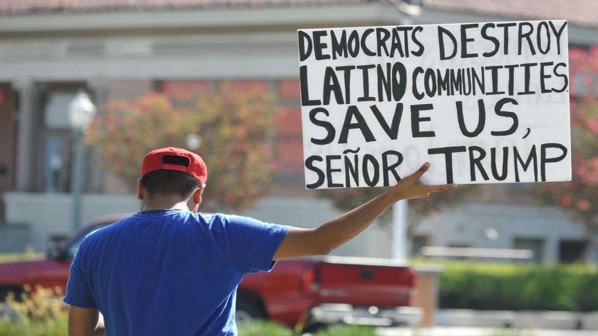 A supporter of Republican presidential nominee Donald Trump holds up a sign for passing cars at a "Latinos For Trump" rally at Anaheim City Hall Sunday.