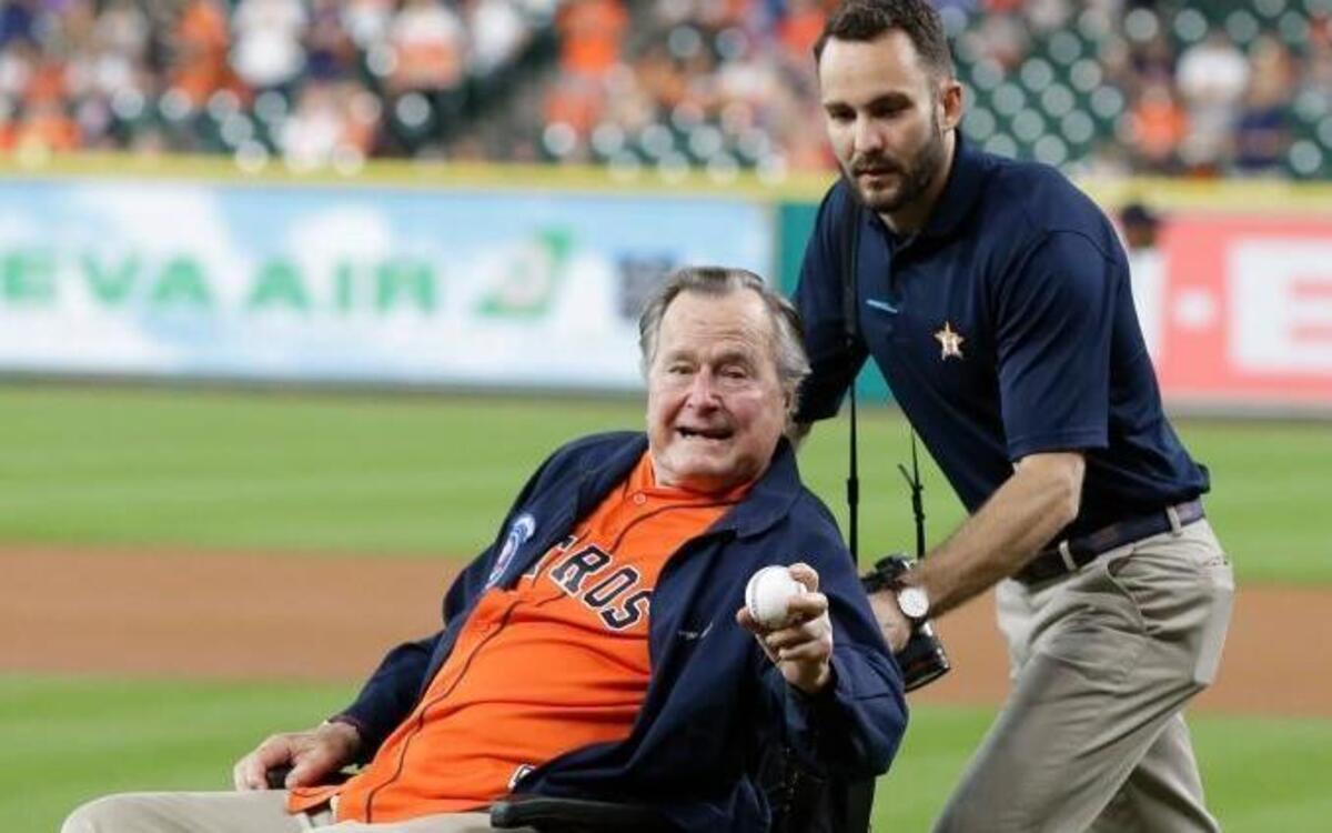 In this April 12, 2016, file photo, former President George H.W. Bush shows his pitching grip as he is wheeled to the field to throw out the ceremonial first pitch to Houston Astros starting pitcher Collin McHugh before the baseball game against the Kansas City Royals in Houston.