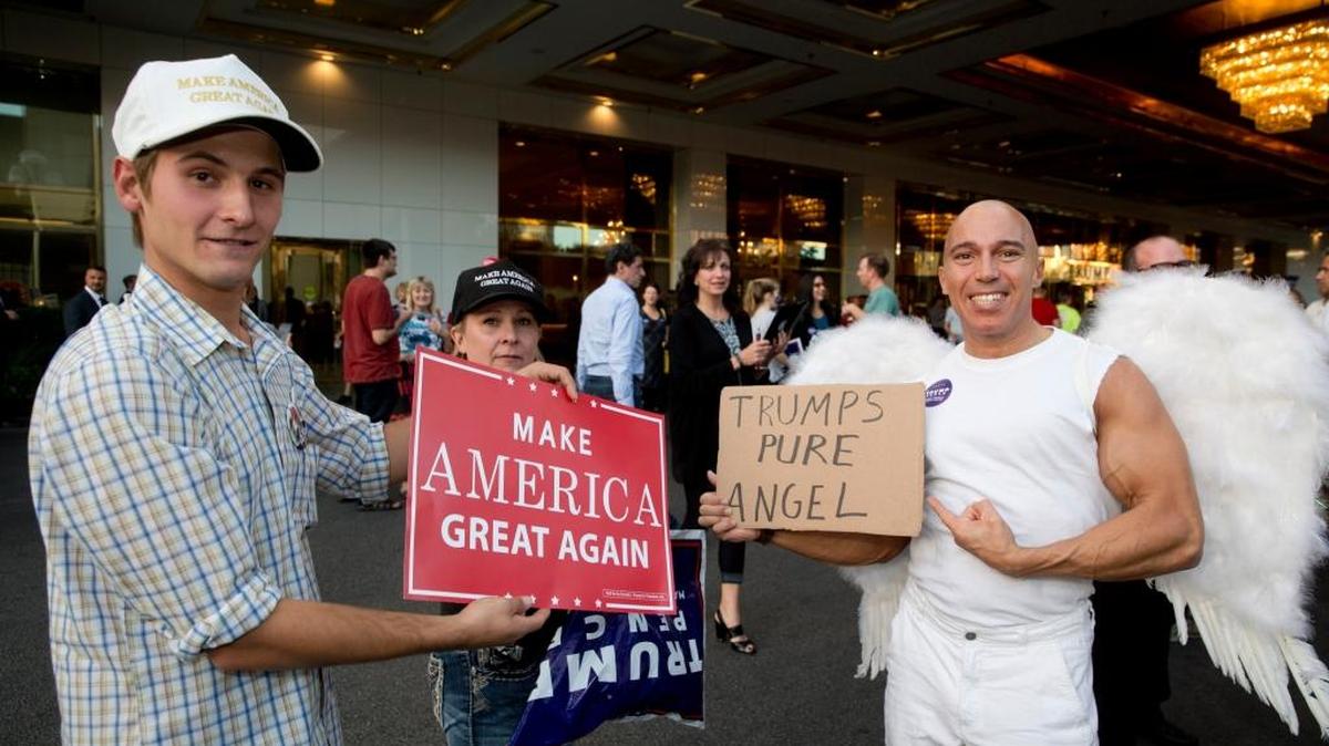 Nick Allen, his mother Stephanie Allen, and Mathew Burgart show their support for Republican presidential nominee Donald Trump rally outside the Trump International Hotel in Las Vegas Tuesday.