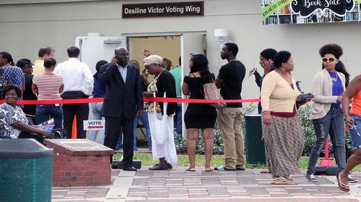 Voters stand in line outside the North Miami Public Library waiting to cast ballots during early voting, Friday, Nov. 4, 2016.