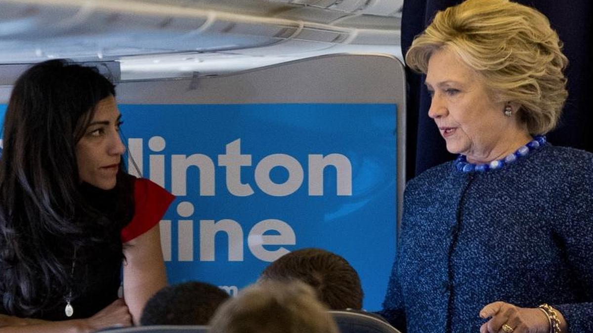 Democratic presidential candidate Hillary Clinton speaks with senior aide Huma Abedin aboard her campaign plane Friday, Oct. 28, 2016, before traveling to Iowa for rallies.