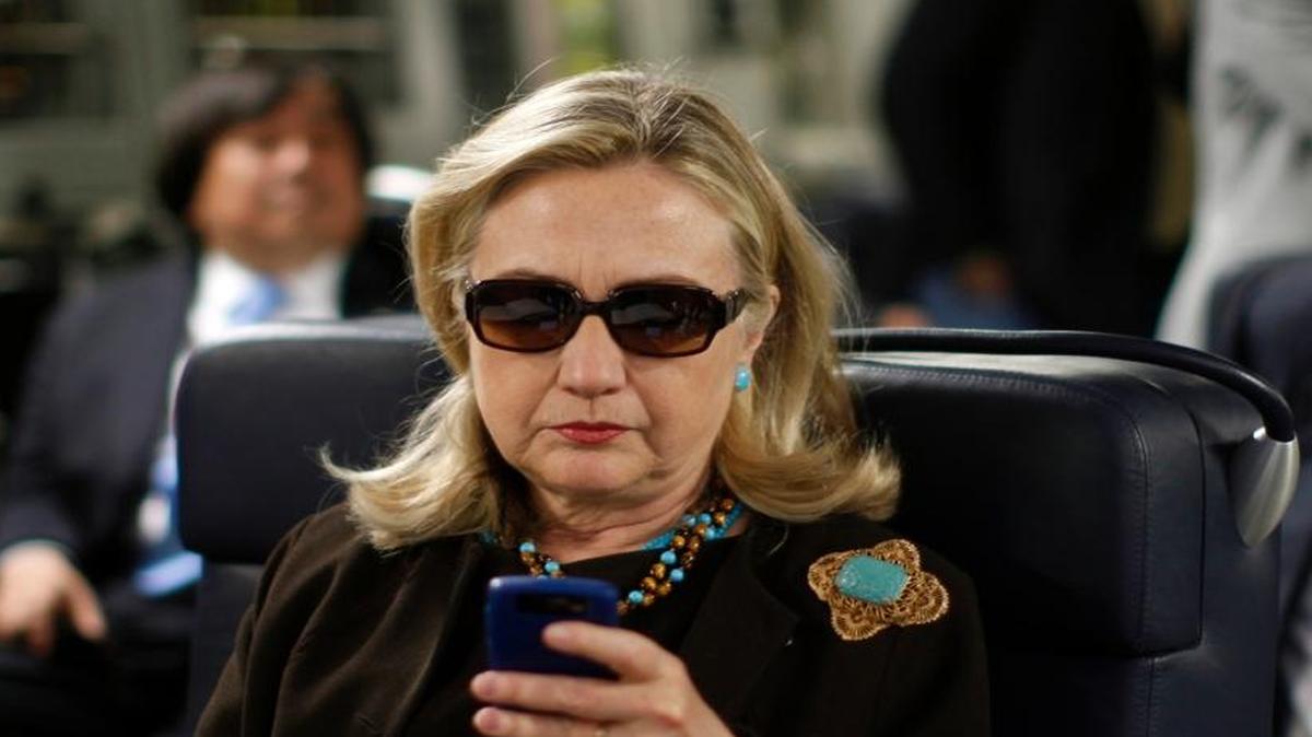 This Oct. 18, 2011, photo shows then-Secretary of State Hillary Clinton checking her Blackberry from a desk inside a C-17 military plane traveling to Tripoli, Libya. The State Department is reopening an internal investigation of possible mishandling of classified information by Hillary Clinton and her top aides.