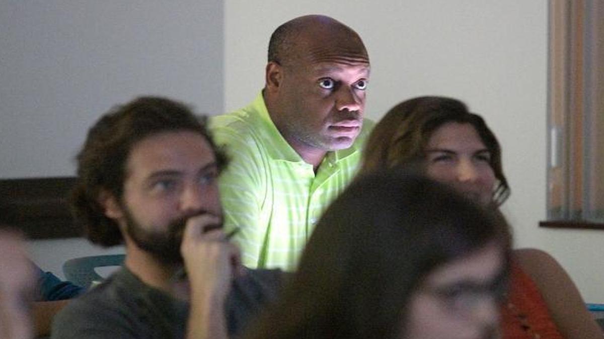 Derek Bruce, center, watches as Democratic Presidential nominee Hillary Clinton talks about trade and open borders during a campaign debate focus group viewing of the third Presidential debate in Orlando, Fla., on Oct. 22, 2016.