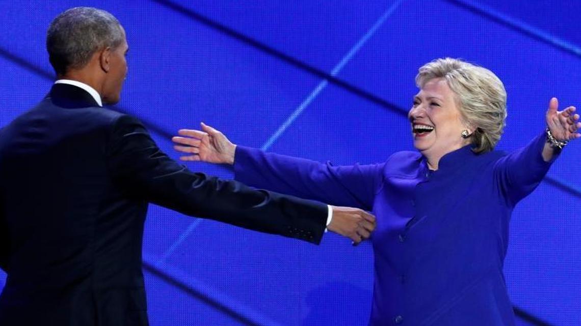 Democratic presidential nominee Hillary Clinton reaches for President Barack Obama as she steps on stage after President Obama's speech during the third day of the Democratic National Convention in Philadelphia , Wednesday, July 27, 2016.