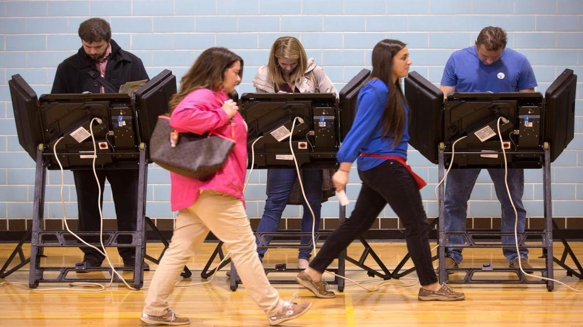 A poll worker leads a voter to an electronic voting machine on Election Day in Ohio last year. As this year’s presidential election approaches, election officials and computer security experts worry that many states still use older machines with outdated technology that could break down or be targeted by hackers, possibly compromising the results.