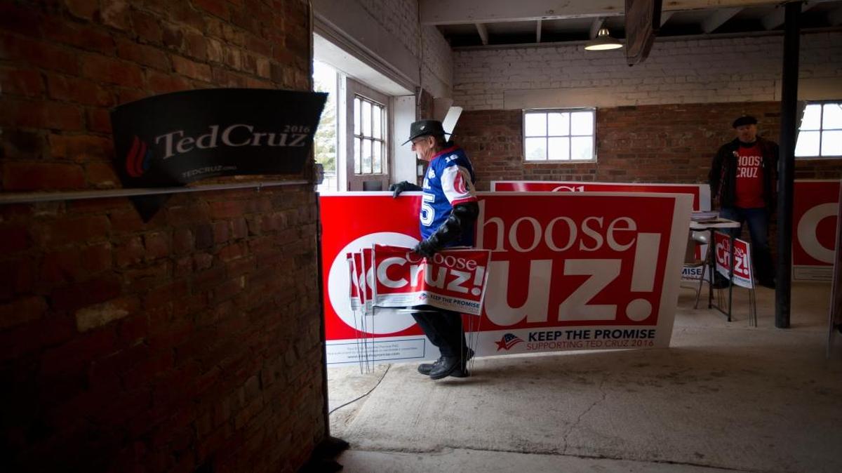 Is Ted Cruz the heir to the legacy of Ronald Reagan and Barry Goldwater? Lloyd Hedrick carries a large sign for Cruz after attending a campaign event in Osceola, Iowa.