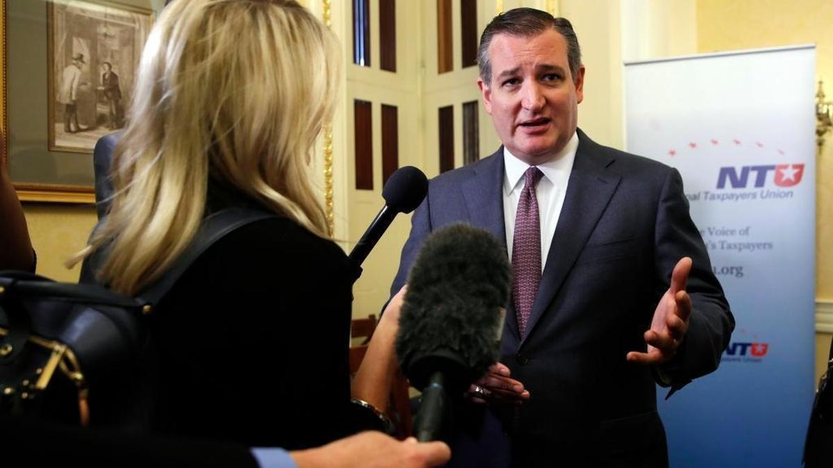 Sen. Ted Cruz, R-Texas, right, answers questions from reporters after a news conference about the Republican tax overhaul on Capitol Hill.