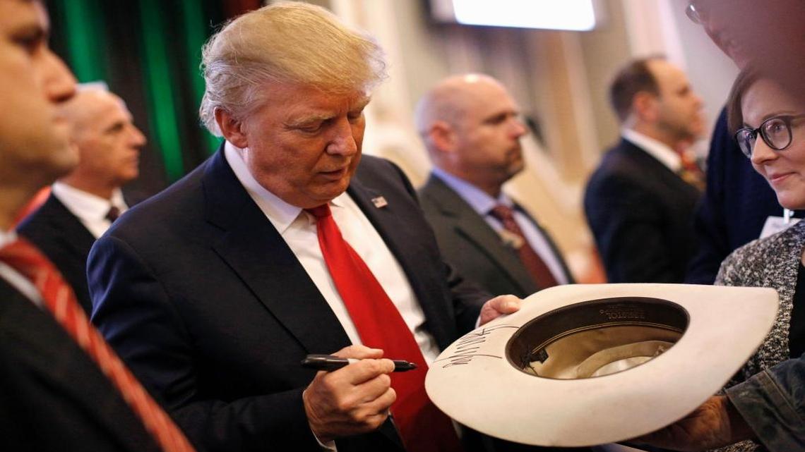 Republican presidential candidate Donald Trump autographs a cowboy hat after speaking at the Iowa Renewable Fuels Summit in Altoona, Iowa, on Tuesday, Jan. 19, 2016.