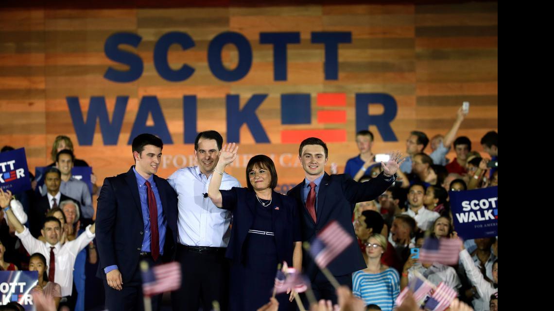 
Wisconsin Gov. Scott Walker acknowledge supporters with his son Alex, left, wife Tonette and other son Matt, as he announces he is running for the 2016 Republican presidential nomination at the Waukesha County Expo Center, Monday, July 13, 2015, in Waukesha, Wis. 
