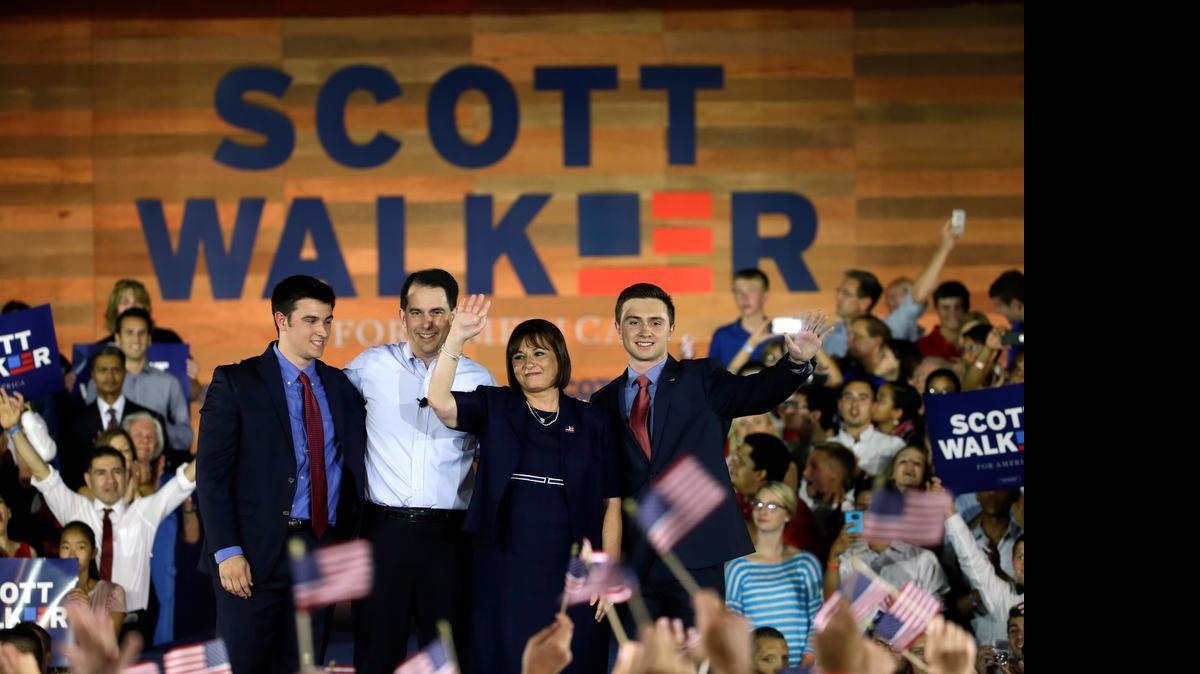 
Wisconsin Gov. Scott Walker acknowledge supporters with his son Alex, left, wife Tonette and other son Matt, as he announces he is running for the 2016 Republican presidential nomination at the Waukesha County Expo Center, Monday, July 13, 2015, in Waukesha, Wis. 
