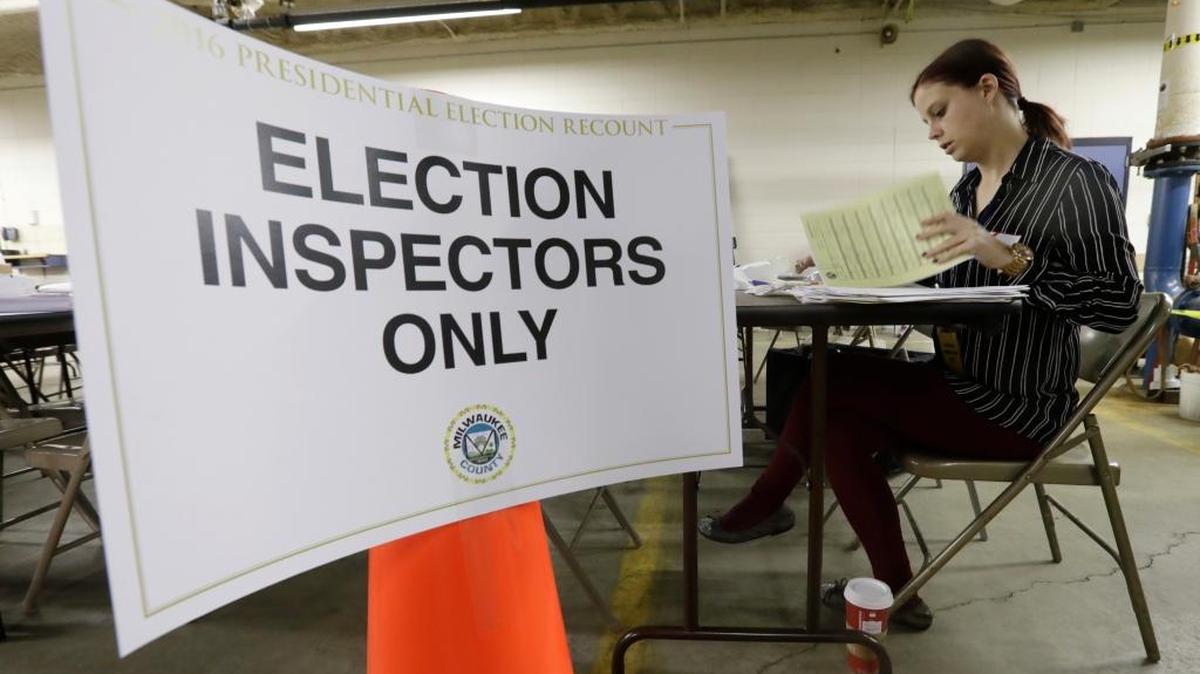 Nicole Kirby looks over results during a statewide presidential election recount Thursday, Dec. 1, 2016, in Milwaukee. The first candidate-driven statewide recount of a presidential election in 16 years began Thursday in Wisconsin. The Trump campaign is fighting to prevent a similar recount in Michigan.