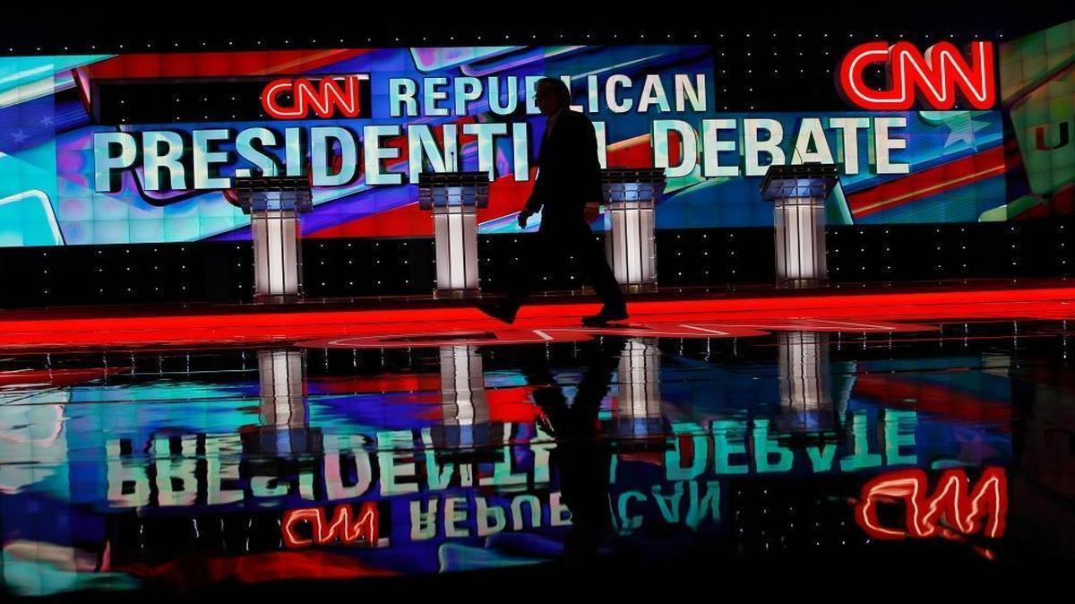 A CNN staffer walks across the stage where the Republican presidential debate sponsored by CNN, Salem Media Group and the Washington Times will take place at the University of Miami on Thursday, March 10, 2016, in Coral Gables, Fla.
