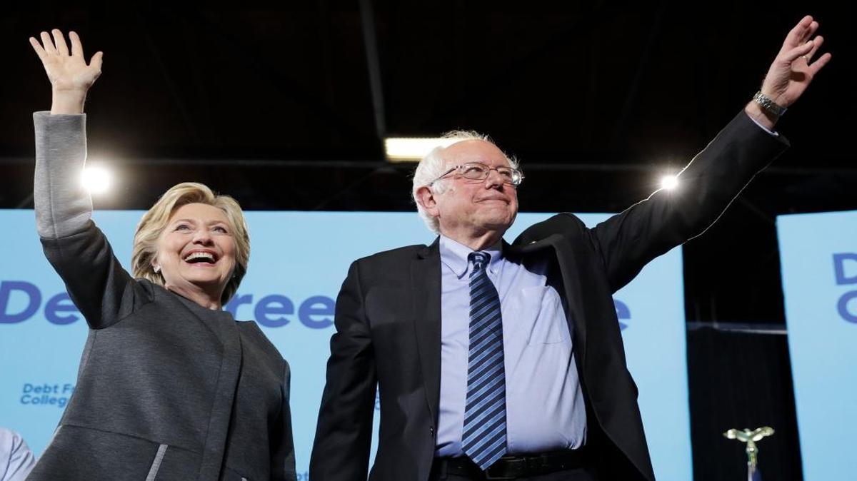 Democratic presidential candidate Hillary Clinton and Sen. Bernie Sanders, I-Vt., take the stage during a campaign stop in New Hampshire this week. He will stump for her in Iowa on Monday, a state where they had their first showdown during the Democratic primaries.
