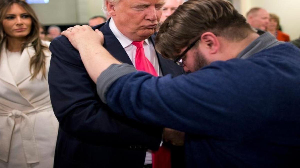 In this Jan. 31, 2016, file photo, Pastor Joshua Nink, right, prays for Republican presidential candidate Donald Trump, as his wife, Melania, left, watches after a Sunday service at First Christian Church, in Council Bluffs, Iowa.