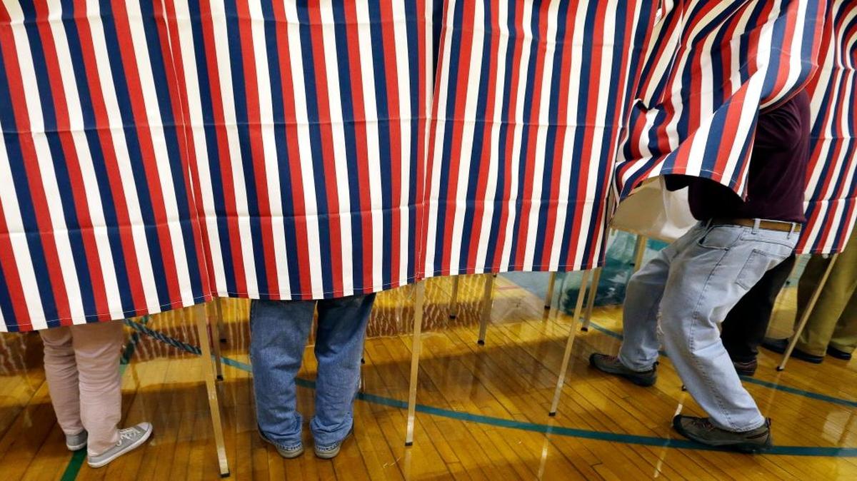 In this Election Day file photo, a voter enters a booth at a polling place in Exeter, N.H. President-elect Donald Trump tweeted himself into a controversy over voter fraud Sunday, claiming that it had occurred in New Hampshire, Virginia and California. On Monday the New Hampshire Attorney General's Office said it didn't have evidence to back up that claim.