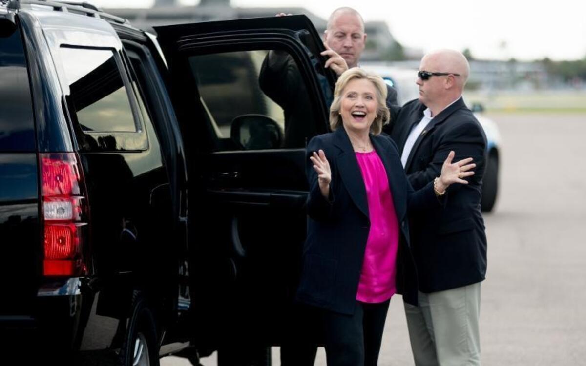 Democratic presidential candidate Hillary Clinton reacts to photojournalists as she arrives to board her campaign plane at Tampa International Airport in Florida on Tuesday, Sept. 6, 2016.